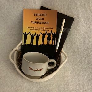 Basket of inspiration, book about overcoming transition, journal, pen, & cup.